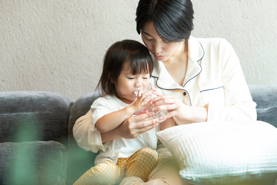 ソファでくつろぐ家族。テーブルにはMiz-Uと水のグラス